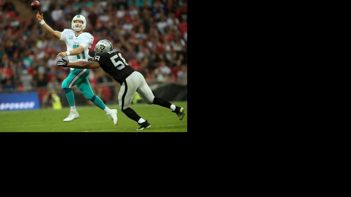 
Ryan Tannehill elude a LaMarr Woodley, de los Raiders, y pasa el ovoide, el domingo en Londres.
