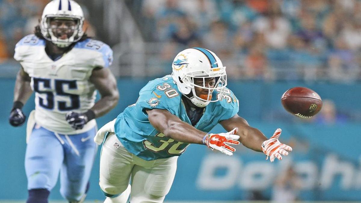 El running back de los Dolphins trata de atrapar un pase del quarterback Zac Dysert, en el partido contra los Titans de Tennessee, el jueves 1ro de septiembre del 2016 en Miami.