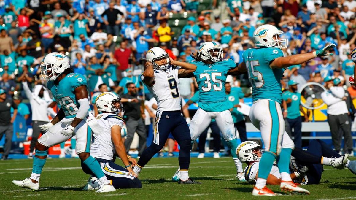El kicker de los Chargers Younghoe Koo (9) se agarra la cabeza luego de fallar en el último segundo del partido un intento de gol de campo que le hubiera dado la victoria a su equipo. Bobby McCain (28), Walt Aikens (35) y Mike Hull (45), de los Dolphins, en cambio, celebran el triunfo en el StubHub Center, el domingo 17 de septiembre del 2017 en Carson, California.