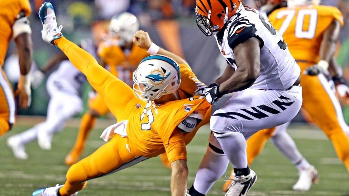 El quarterback de los Dolphins Ryan Tannehill es derribado por Geno Atkins, de los Bengals, en el Paul Brown Stadium en Cincinnati, Ohio, la noche del jueves 29 de septiembre del 2016.