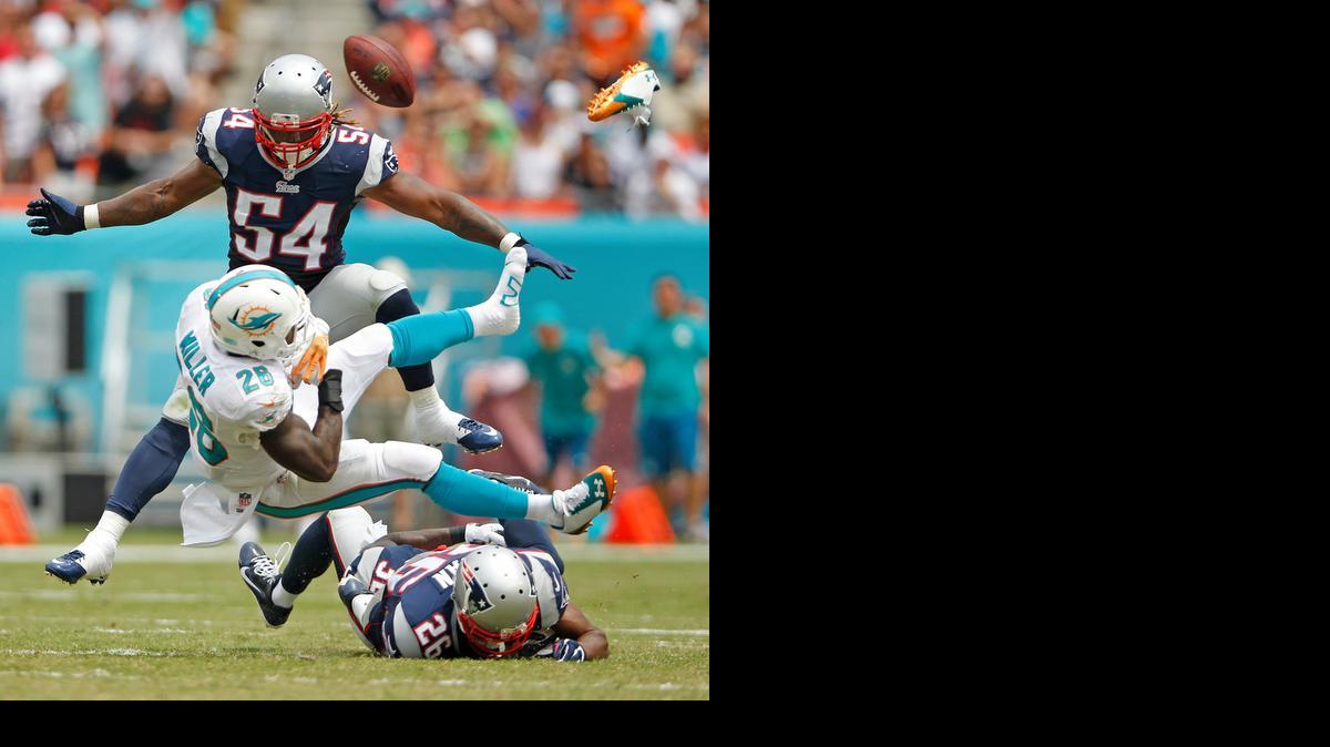 
El running back de Miami Lamar Miller (26) pierde el ovoide y un zapato durante una jugada en el segundo cuarto del partido entre los Dolphins y los Patriots, el domingo en el Sun Life Stadium de Miami.


