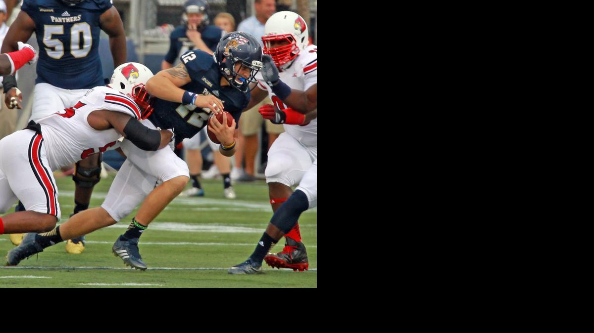 
El quarterback de FIU Alex McGough (#12) es derribado por el jugador de Louisville Jake Smith.


