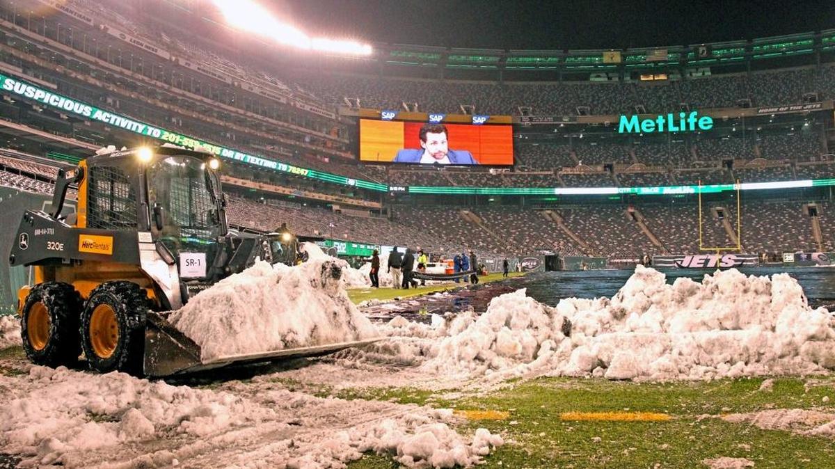 Los trabajadores remueven la nieve antes del partido entre los Dolphins de Miami y los Jets de Nueva York Jets en el MetLife Stadium en East Rutherford, New Jersey, el sábado 17 de diciembre del 2016.