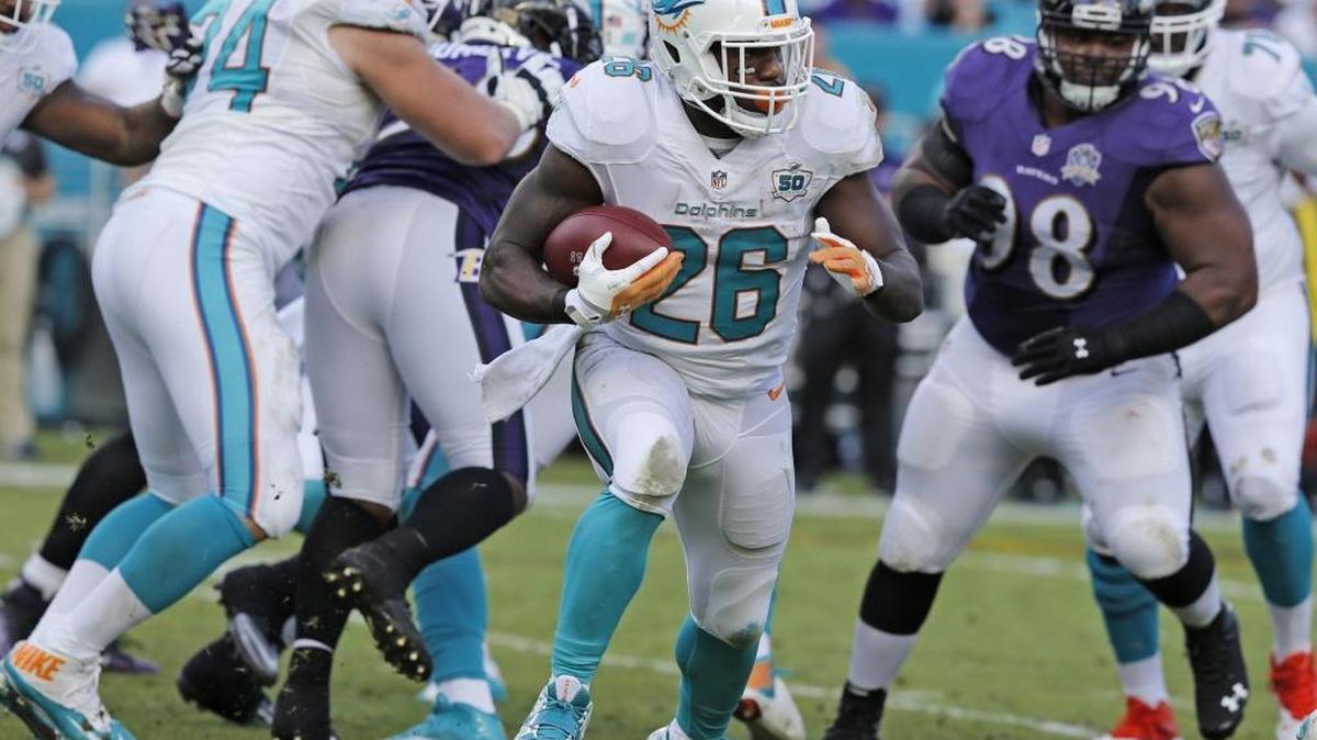 Lamar Miller (26) se escapa con el ovoide en el triunfo de los Dolphins sobre los Ravens, en el Sun Life Stadium en Miami, el domingo 6 de diciembre del 2015.