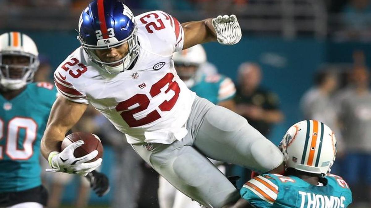 El defensive back de los Dolphins Michael Thomas (der.) derriba al running back de los Gianst Rashad Jennings, en el partido del lunes 14 de diciembre del 2015 en Miami.