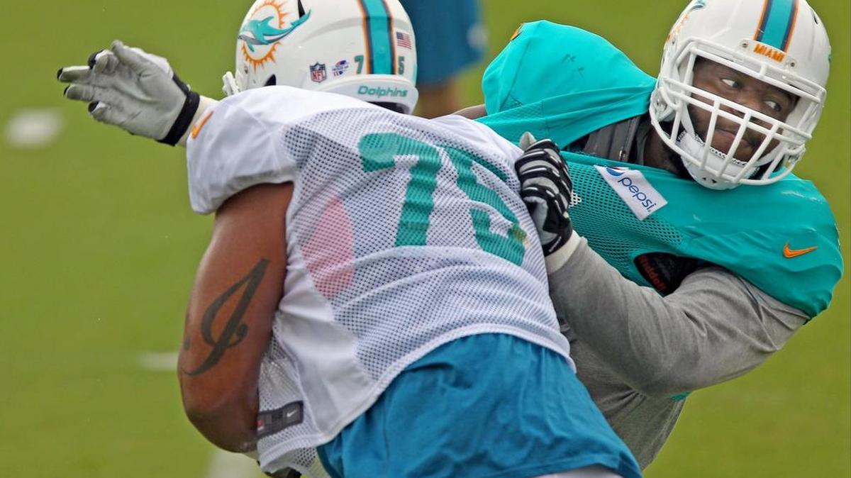 
Jordan Phillips (der.) y Jamil Douglas en el entrenamiento de los Dolphins en Davie, Florida, el 2 de agosto del 2015.
