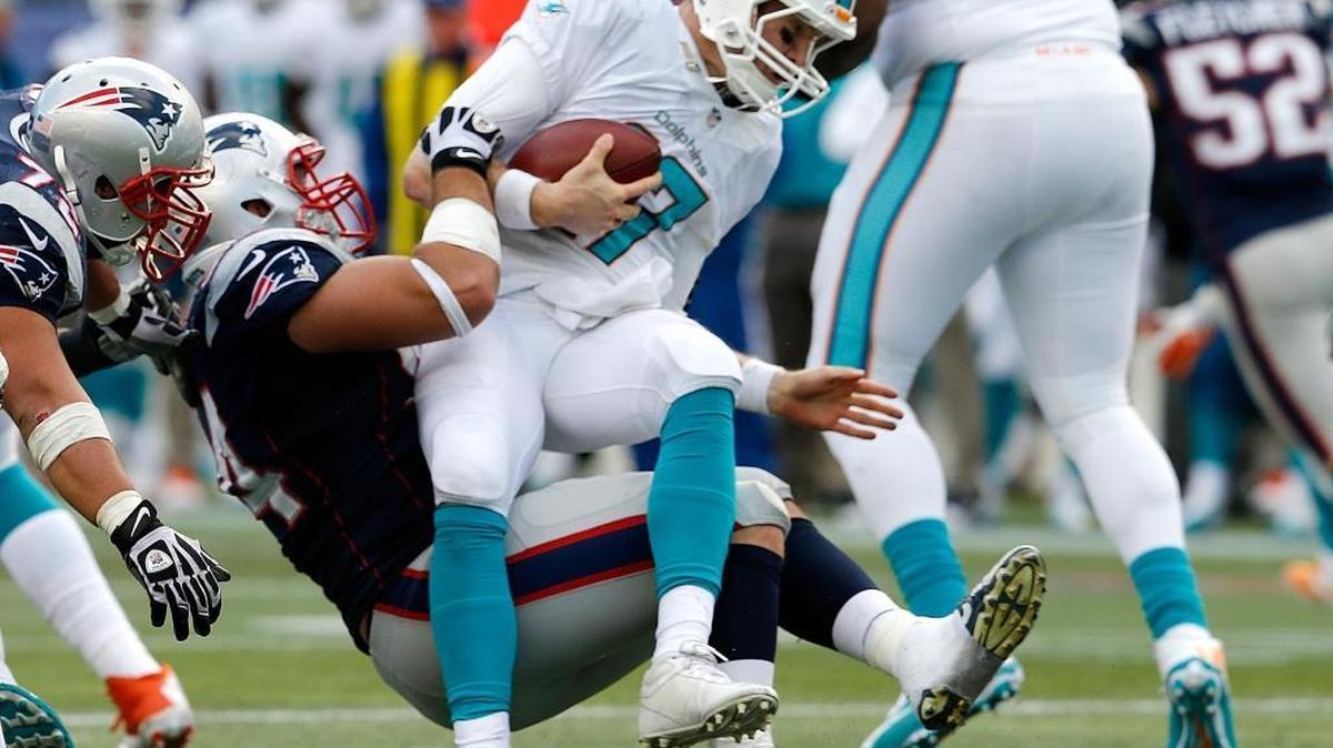 Chris Jones, de los Patriots, derriba a Ryan Tannehill, de los Dolphins, el 2013.