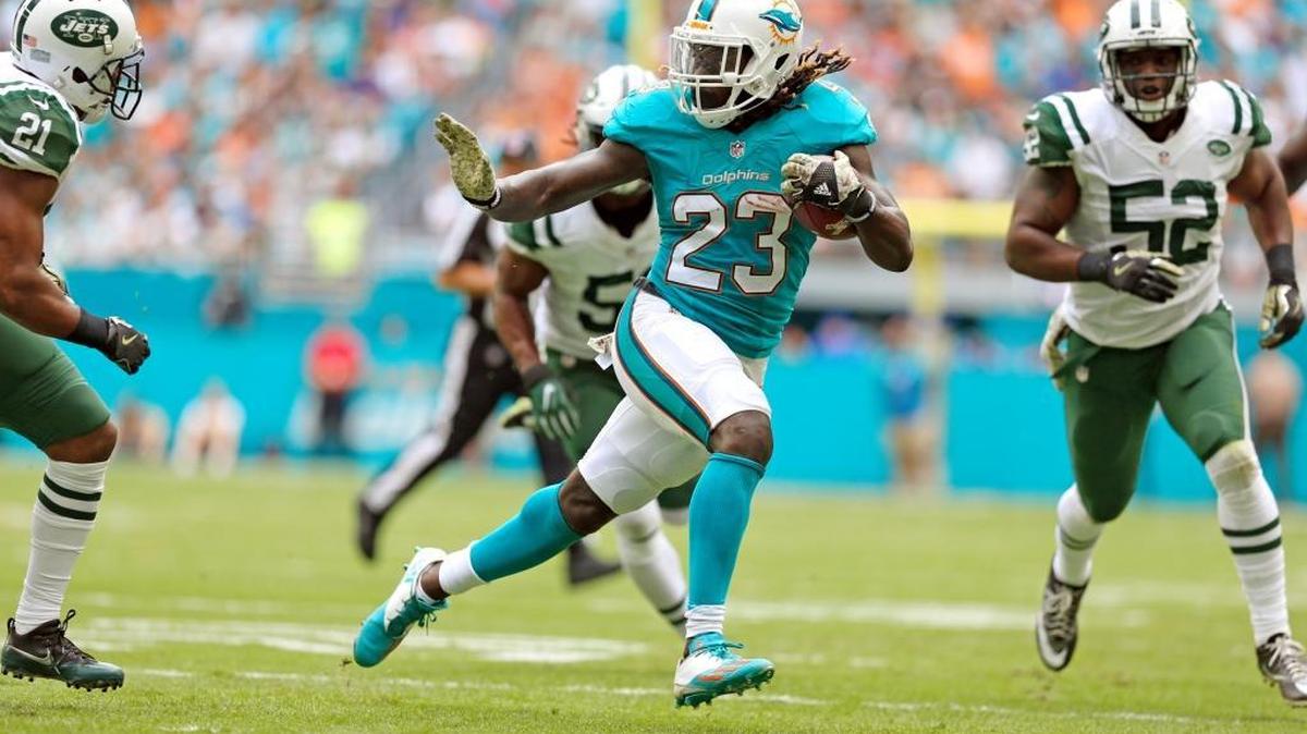 El running back de los Dolphins Jay Ajayi (23) corre para anotar un touchdown de 20 yardas en el primer cuarto contra los Jets de Nueva York en el Hard Rock Stadium, el domingo 6 de noviembre del 2016 en Miami.