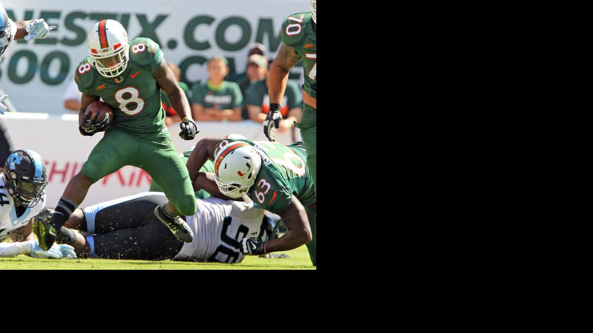 
DUKE JOHNSON, de los Huracanes completa yardas en partido contra Carolina, en Miami.
