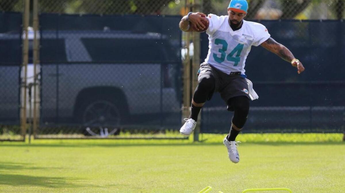 El running back de los Dolphins de Miami Arian Foster (34) realiza ejercicios en el primer día del campamento de entrenamiento, el viernes 29 de julio del 2016.