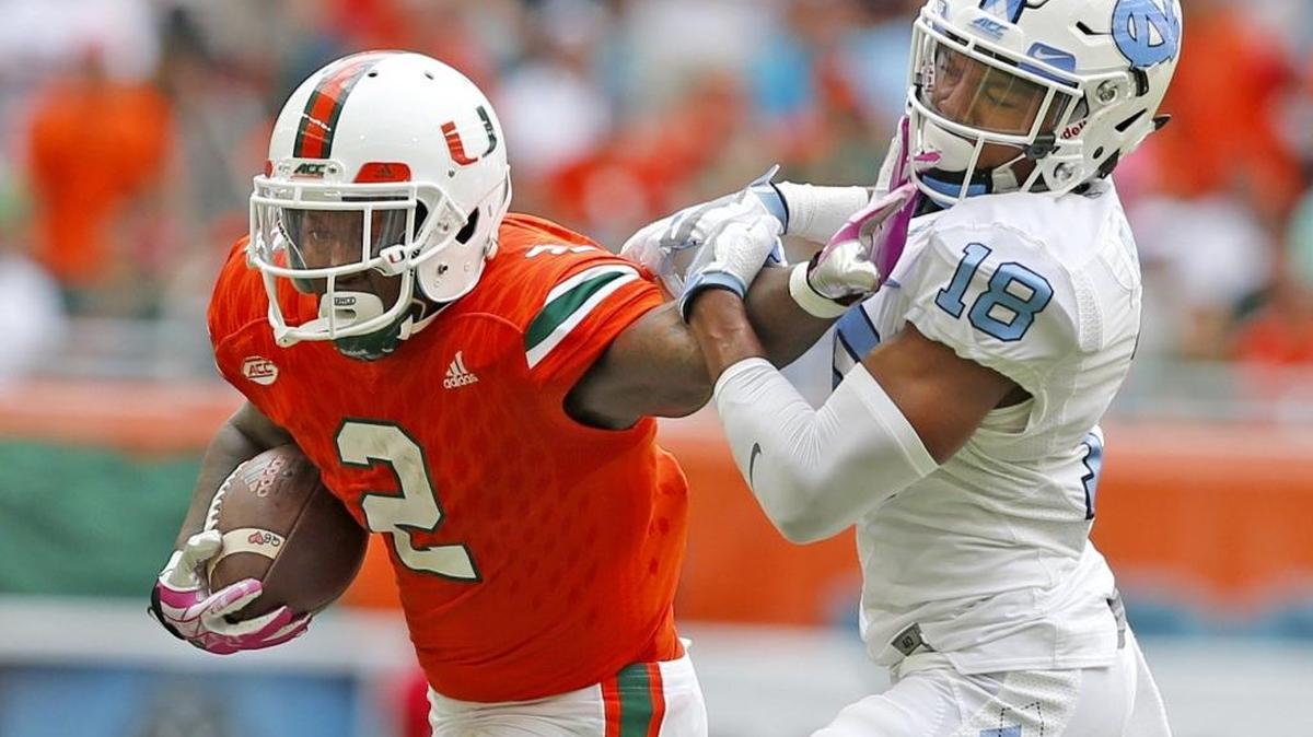 El running back Joseph Yearby (2), de los Huracanes, lucha con el cornerback de los Tar Heels de North Carolina Corey Bell Jr. (18), en el partido contra North Carolina, en el Hard Rock Stadium el sábado 15 de octubre del 2016, en Miami.