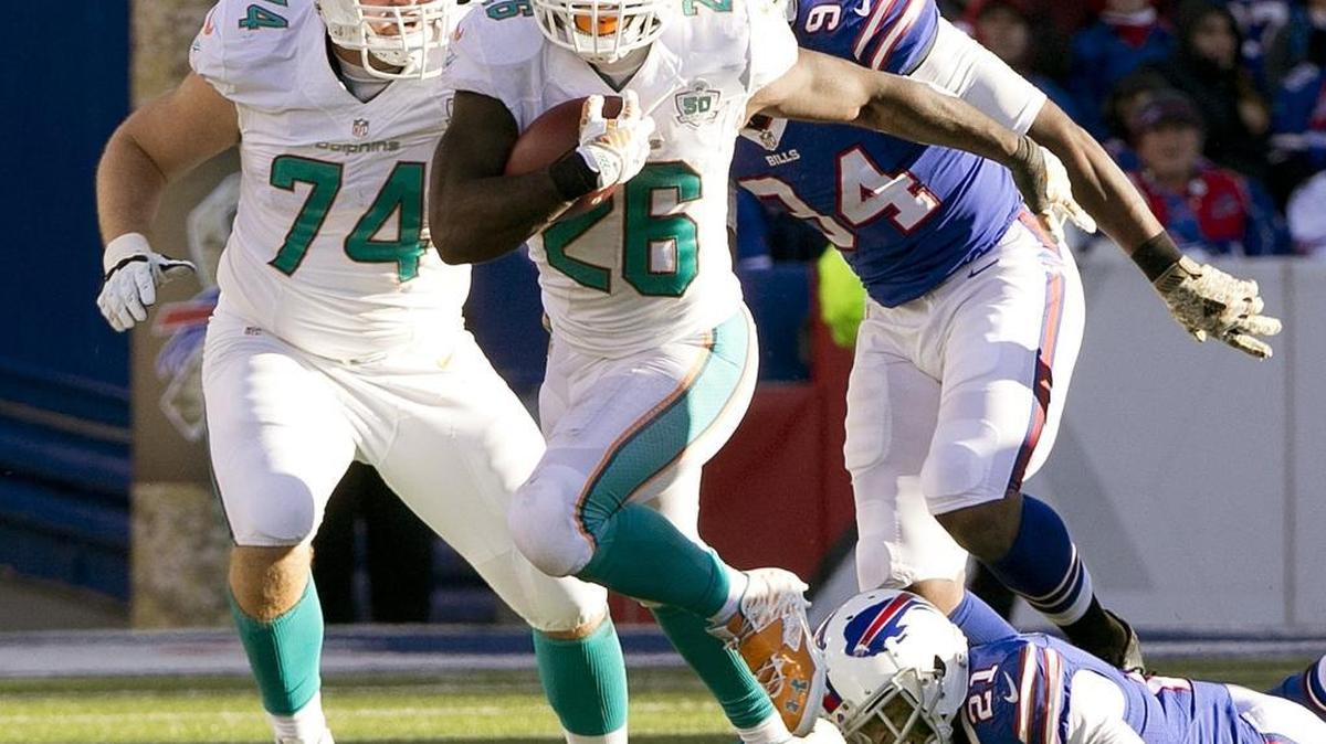 Lamar Miller (26), de los Dolphins, se escapa con el ovoide, el domingo pasado en la caída contra los Bills.
