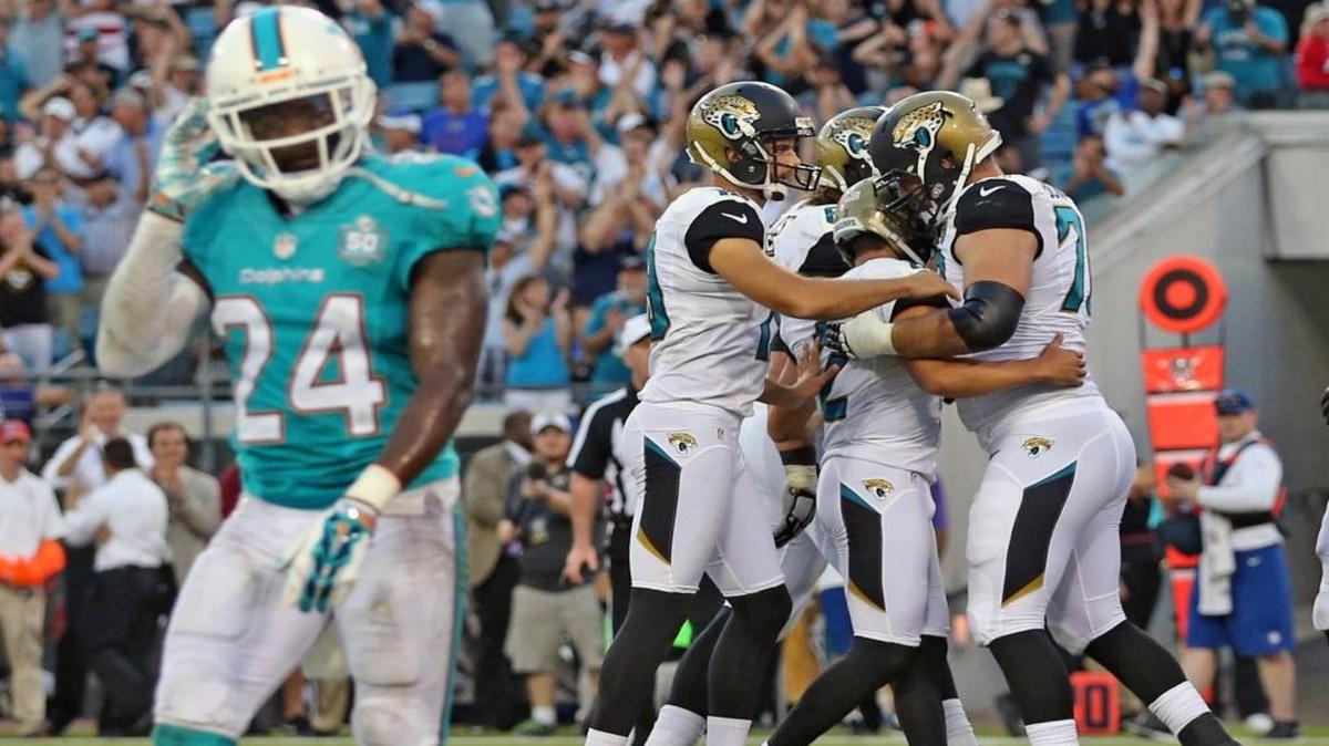 
Brice McCain (24) refleja la derrota de los Dolphins, mientras al fondo celebran los Jaguars, el domingo.
