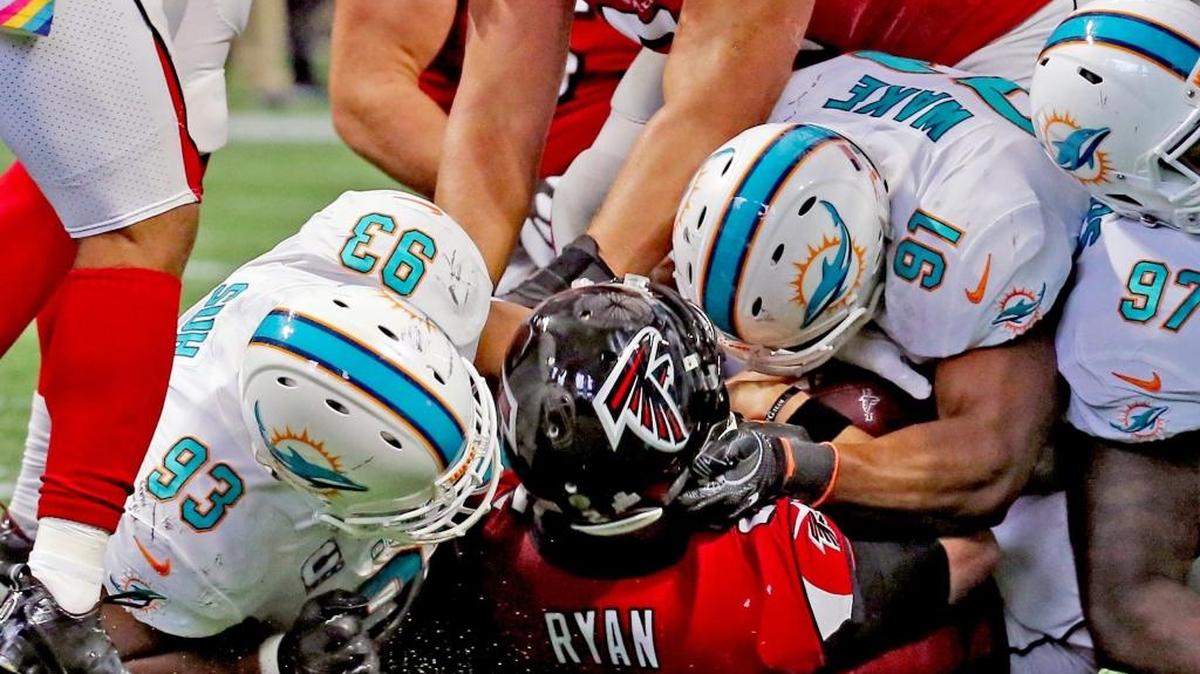 Ndamukong Suh (93) y Cameron Wake (91), de los Dolphins, aplastan al quarterback Matt Ryan (2), de los Falcons, en el segundo cuarto del partido en el Mercedes-Benz Stadium en Atlanta, Georgia, el domingo 15 de octubre del 2017.