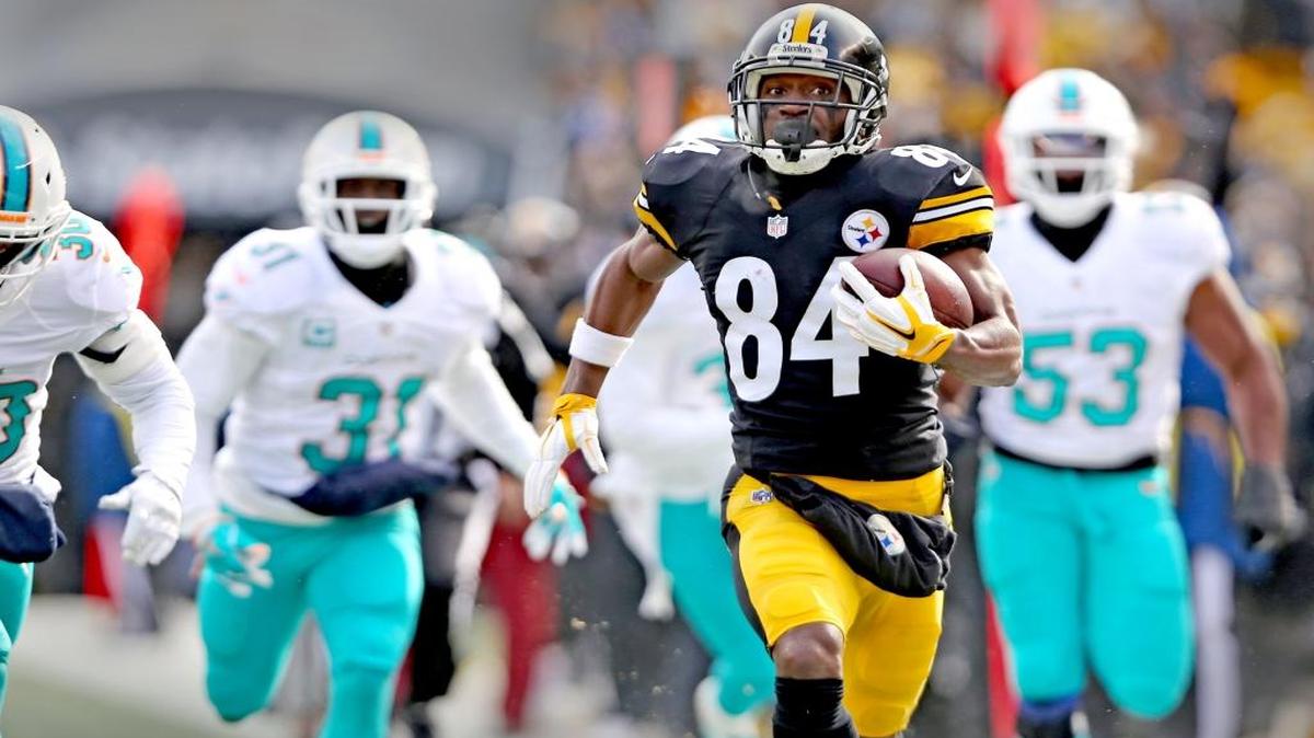 Michael Thomas (31) y Jelani Jenkins (53), de los Dolphins, no pueden alcanzar a Antonio Brown, quien se escapa para anotar un touchdown para los Steelers en el primer cuarto en el Heinz Stadium, en Pittsburgh, el domingo 8 de enero del 2017.