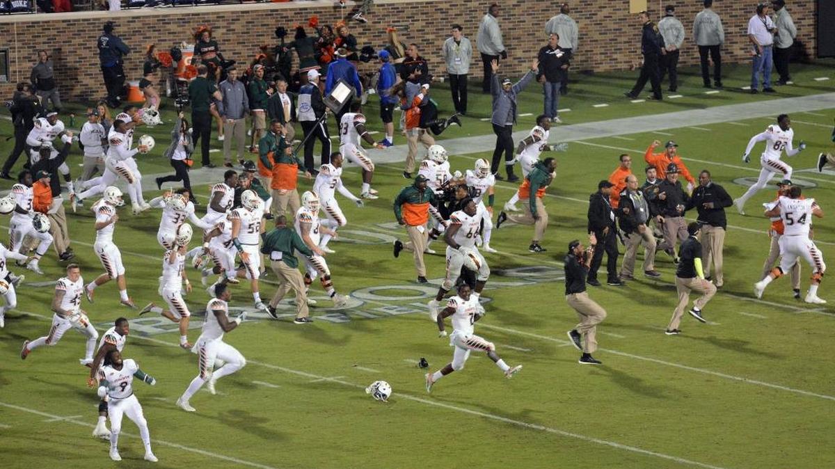 Los jugadores de la UM corren por el campo para celebrar la victoria 30-27 sobre Duke en los segundos finales de un partido del NCAA college football, la noche del sábado 31 de octubre del en Durham, N. C.