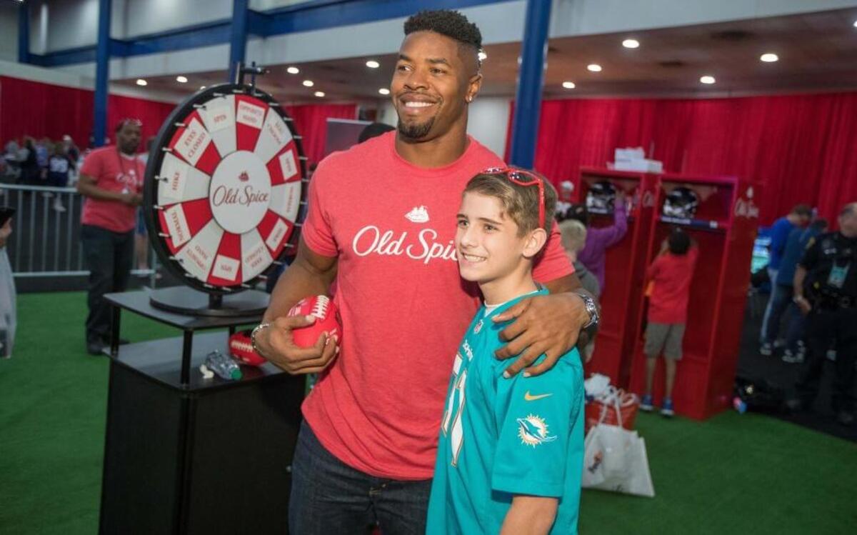 Cameron Wake participa en la Experiencia del Super Bowl LI de la NFL al lado de un fan de los Dolphins, el viernes.