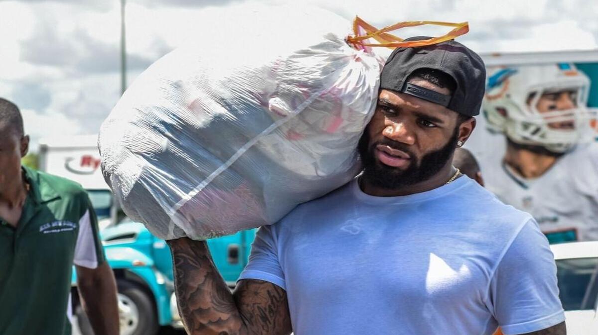 Xavien Howard carga una bolsa durante la recolección de provisiones que hicieron el viernes los Dolphins, la Fundación AARP y All My Sons Moving & Storage para llevar ayuda a Houston a las víctimas del huracán Harvey.