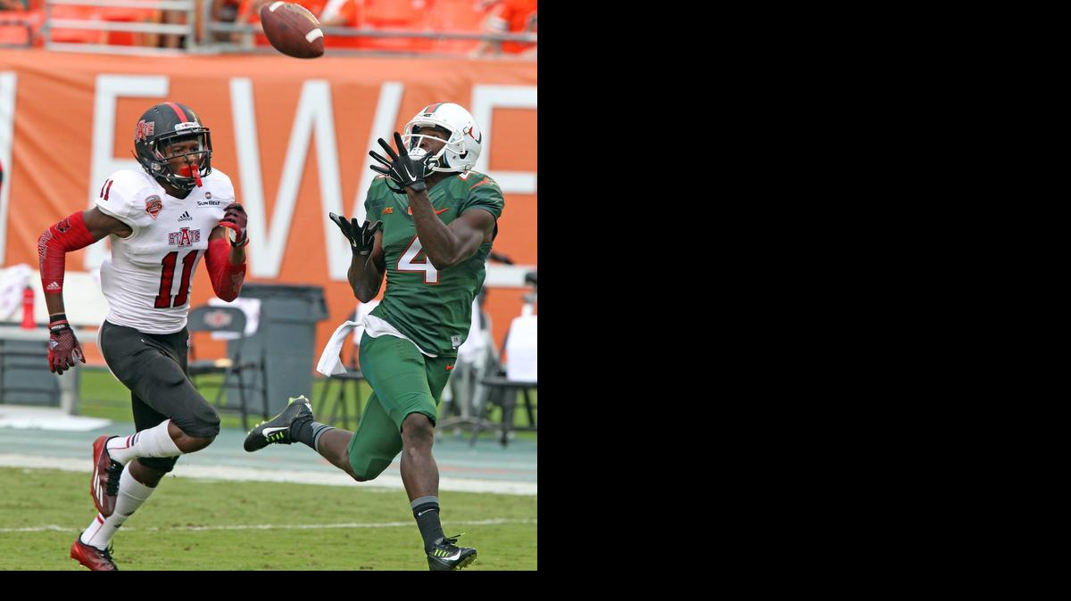 
 Philip Dorsett, de la UM (der.), realiza una captura de 64 yardas sobre el jugador de Arkansas State's Sterling Young.


