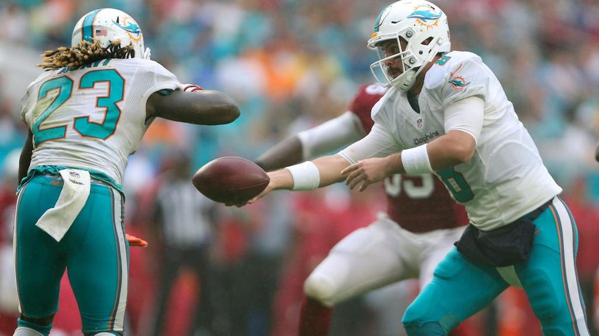 El quarterback de los Dolphins Matt Moore (der.) entrega el ovoide al running back Jay Ajayi en el partido contra los Cardinals de Arizona, celebrado el domingo 12 de diciembre del 2016 en el Hard Rock Stadium, en Miami Garden, Florida.
