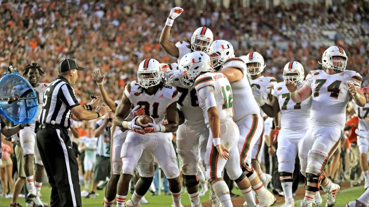 Los jugadores de los Huracanes de Miami celebran con el wide receiver Darrell Langham (izq.) quien anotó un touchdown en los segundos finales del partido contra Florida State, el 7 de octubre de 2017, en Tallahassee, Florida.