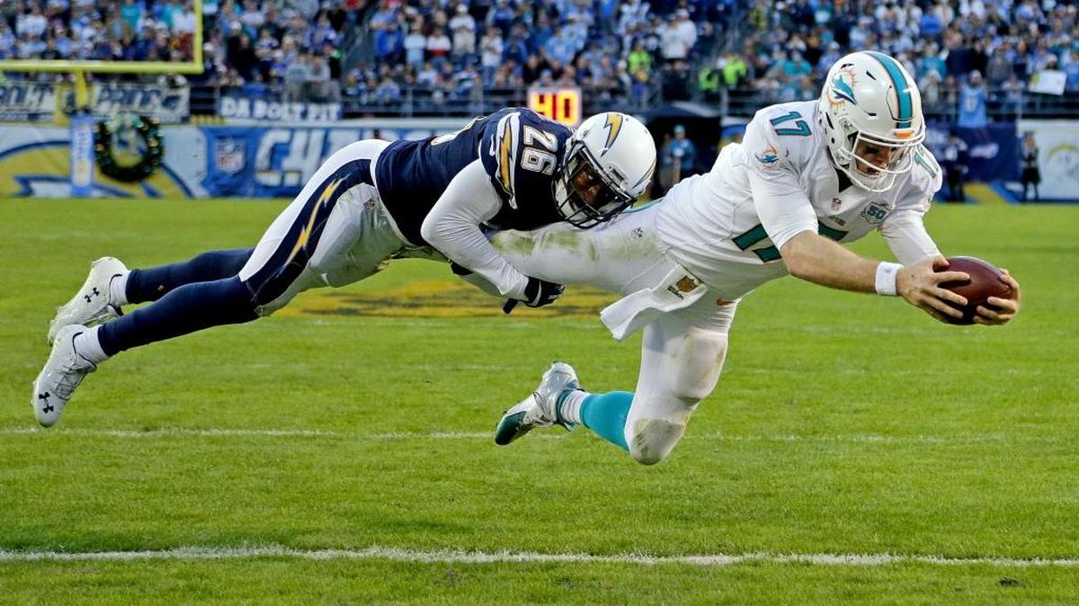 Ryan Tannehill, de losDolphins, anota un touchdown pese a la marcación de Patrick Robinson, el domingo pasado en San Diego.