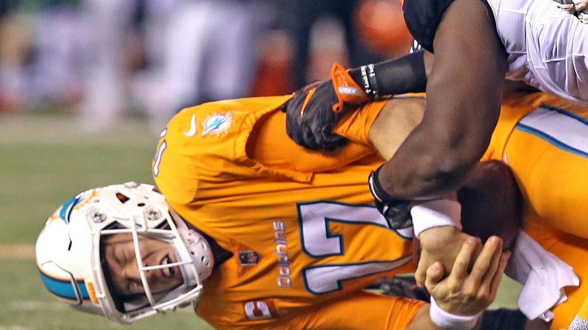 El quarterback de los Dolphins Ryan Tannehill es derribado en el cuarto periodo en la derrota contra los Bengals, en el Paul Brown Stadium en Cincinnati, Ohio, la noche del jueves 29 de septiembre del 2016.