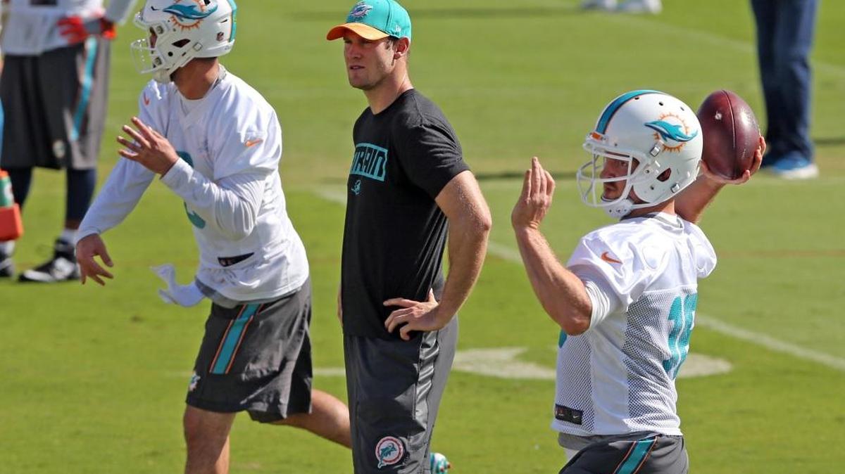 Ryan Tannehill mira las prácticas de los quarterbacks Matt Moore (izq.) y T.J. Yates, el viernes en Davie.
