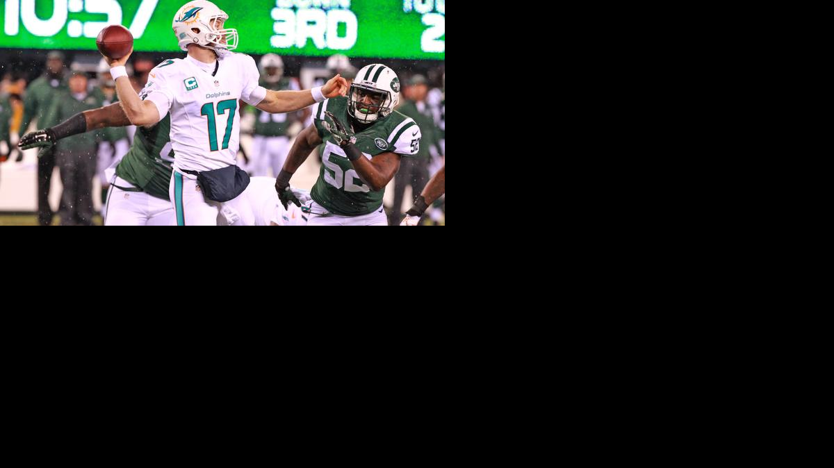 
Ryan Tannehill trata de pasar el ovoide, acosado por la defensiva de los Jets de Nueva York, en el decisivo choque contra los Dolphins, la noche del lunes, en el MetLife Stadium, en East Rutherford, Nueva Jersey.
