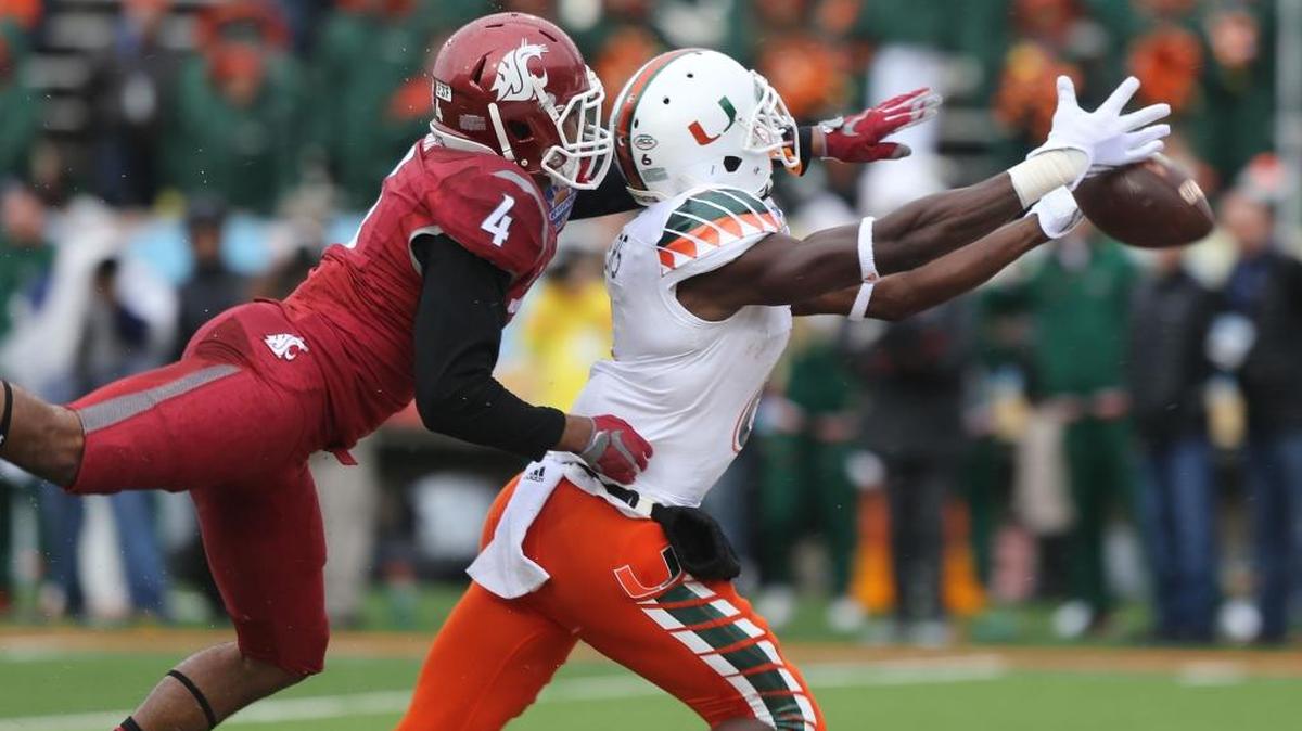 El wide receiver de los Huracanes Herb Waters se estira para alcanzar el ovoide marcado por el defensor de Washington State Charleston White, en el Sun Bowl NCAA de football universitario, el sábado 26 de diciembre del 2015 en El Paso, Texas.