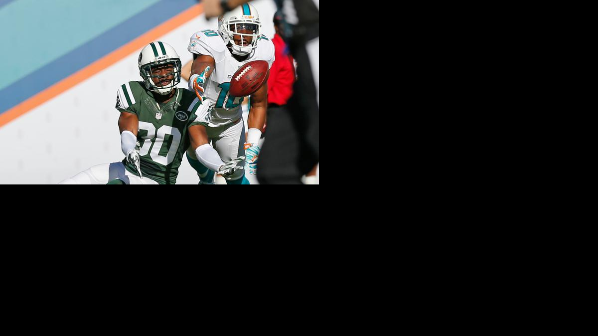 
El wide receiver de los Dolphins Brandon Gibson (#10) trata de capturar el ovoide ante el cornerback de los Jets Darrin Walls (30).


