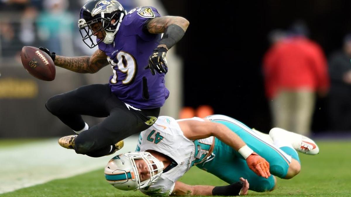 Kiko Alonso (con un protector en la mano derecha), de los Dolphins, frena a Steve Smith, de los Ravens, el domingo 4 de diciembre del 2016, en Baltimore.