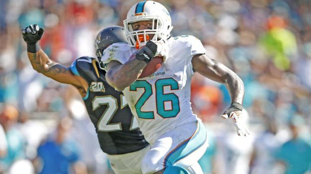 
Lamar Miller (26) escapa con el ovoide en el choque contra los Jaguars, en octubre pasado en Jacksonville.
