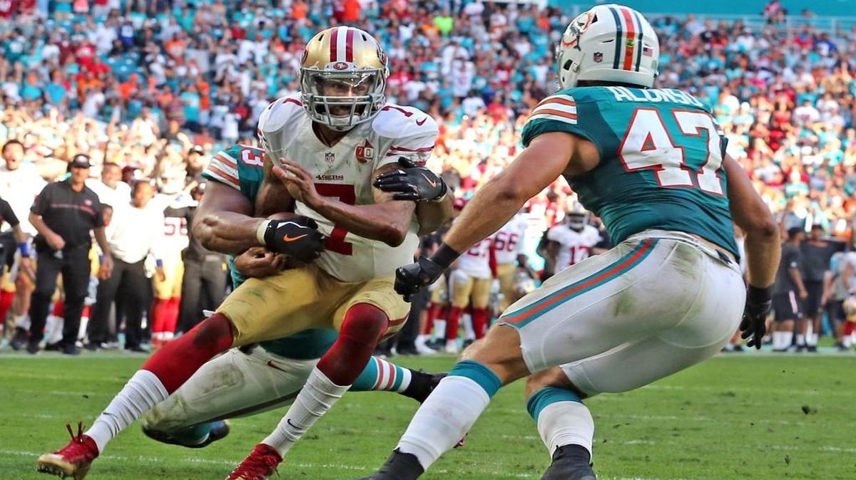 Ndamukong Suh, de los Dolphins, frena al quarterback de los 49ers de San Francisco Colin Kaepernick y Kiko Alonso (47) espera para completar el trabajo en el segundo final del partido en el Hard Rock Stadium en Miami, el 27 de noviembre del 2016.