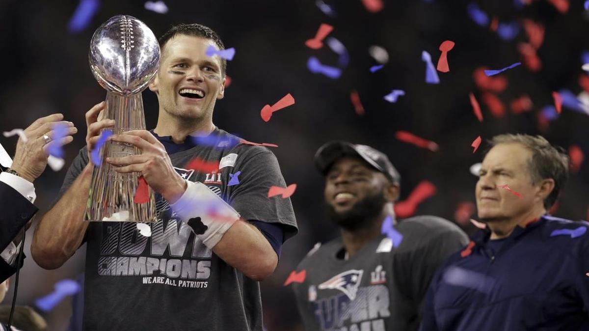 El quarterback de los Patriots Tom Brady levanta el trofeo Vince Lombardi al lado de James White y el entrenador Bill Belichick, luego de la victoria 34-28 sobre los Falcons en tiempo extra en el Super Bowl 51, celebrado el 5 de febrero del 2017 en el NRG Stadium en Houston, Texas.
