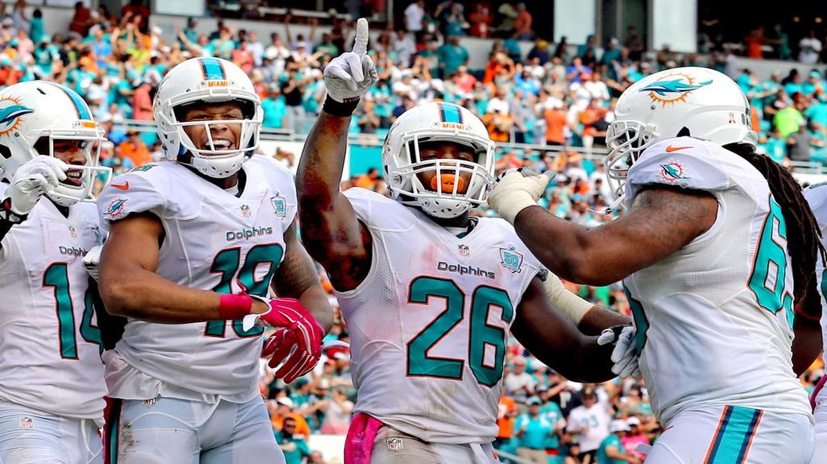 Lamar Miller (#26) celebra con Rishard Matthews (#18) y Jarvis Landry (#14) después de anotar un touchdown en el segundo cuarto para los Dolphins en el partido contra los Texans, el 25 de octubre del 2015.