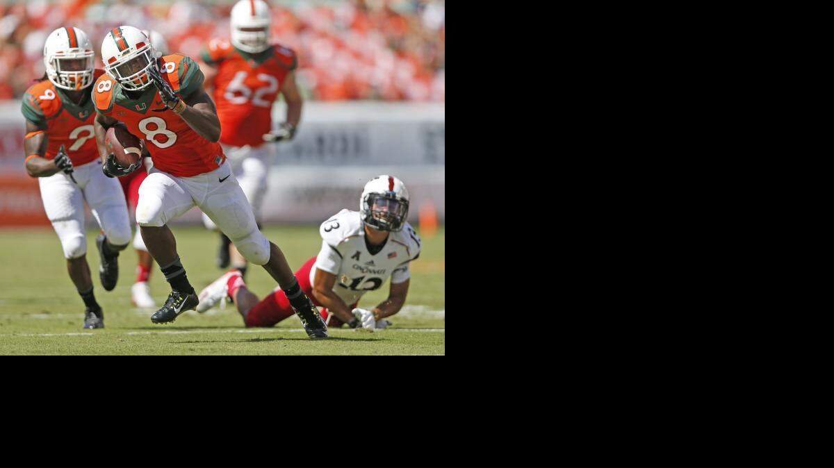 
El running back de los Huracanes Duke Johnson (#8) corre con el ovoide en un partido contra Cincinnati, el 11 de octubre en elSun Life Stadium, en Miami


