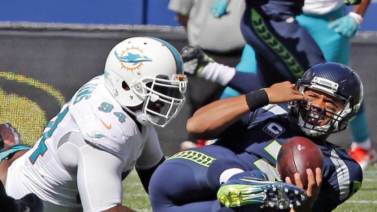 Mario Williams (izq.), de los Dolphins, derriba al quarterback Russell Wilson, de los Seahawks, en el primer cuarto del partido contra los Seahawks en el CenturyLink Field en Seattle, Washington, el 11 de septiembre del 2016.