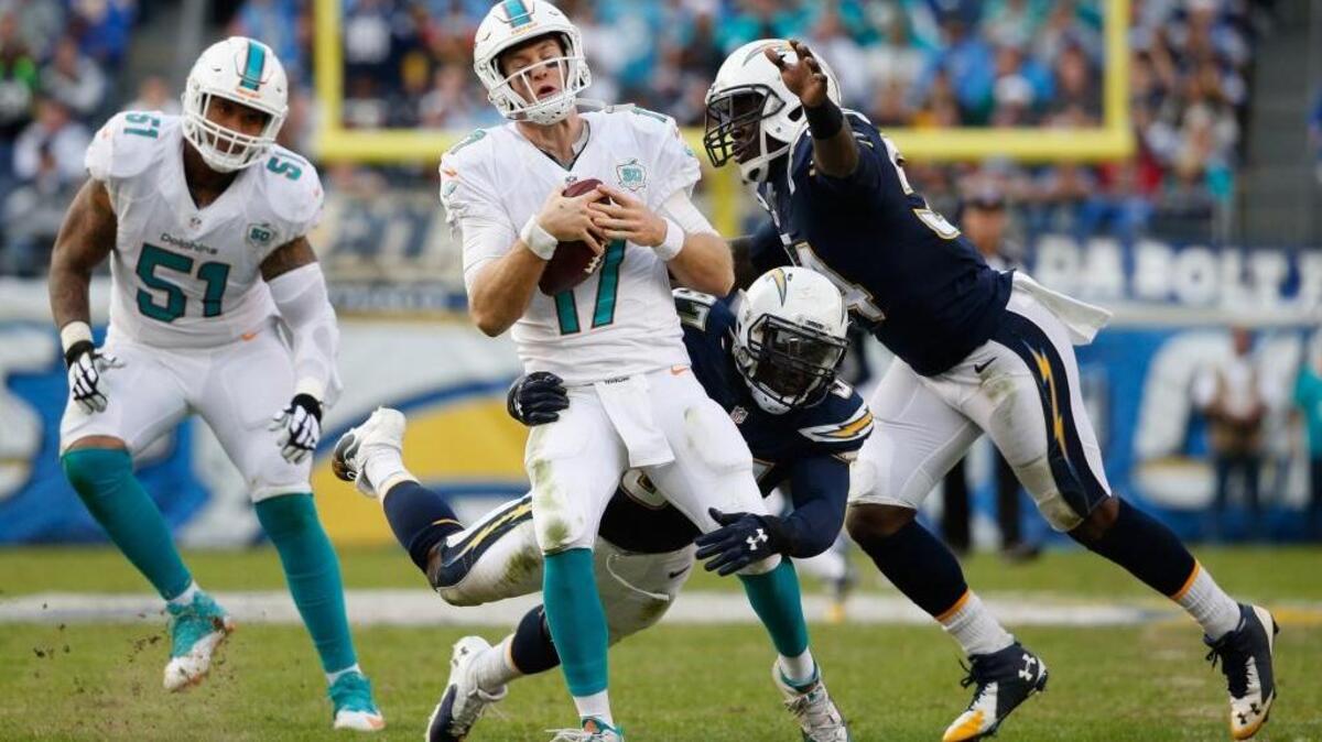 Mike Pouncey (51) no puede evitar que los Chargers derriben a Ryan Tannehill, de los Dolphins, el domingo.
