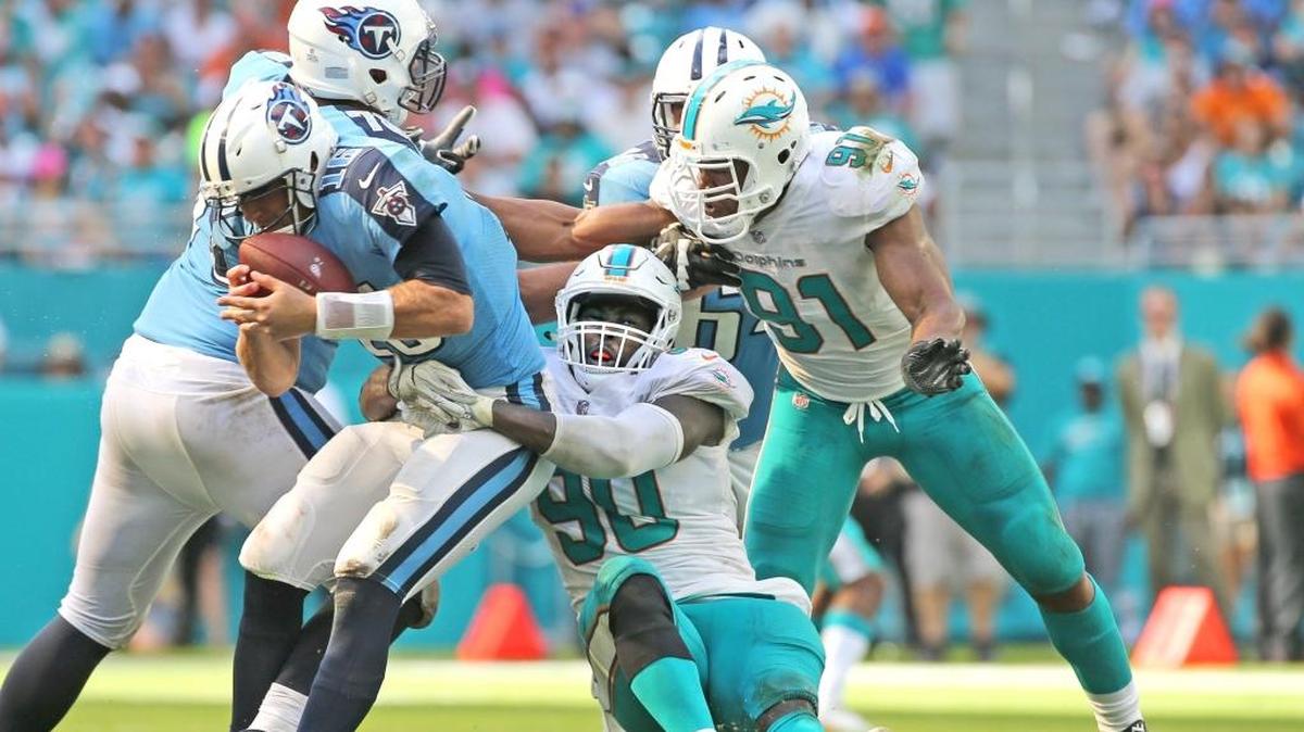 El novato Charles Harris (90), de los Dolphins, derriba a Matt Cassel (16), de los Titans, con la ayuda de Cameron Wake (91), en el Hard Rock Stadium, el 8 de octubre del 2017.