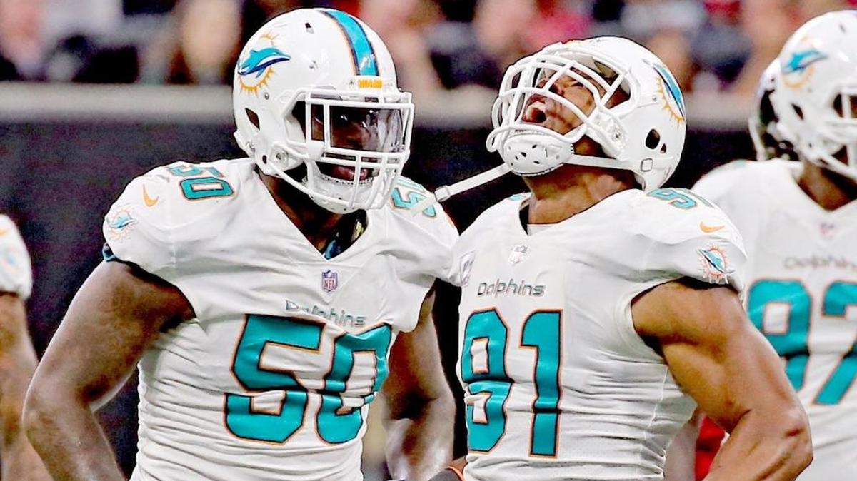 Andre Branch (50) y Cameron Wake (91), de los Dolphins, celebran luego de haber derribado al quarterback Matt Ryan (no aparece en la foto), de los Falcons, en el cuarto periodo en el Mercedes-Benz Stadium en Atlanta, Georgia, el domingo 15 de octubre del 2017.