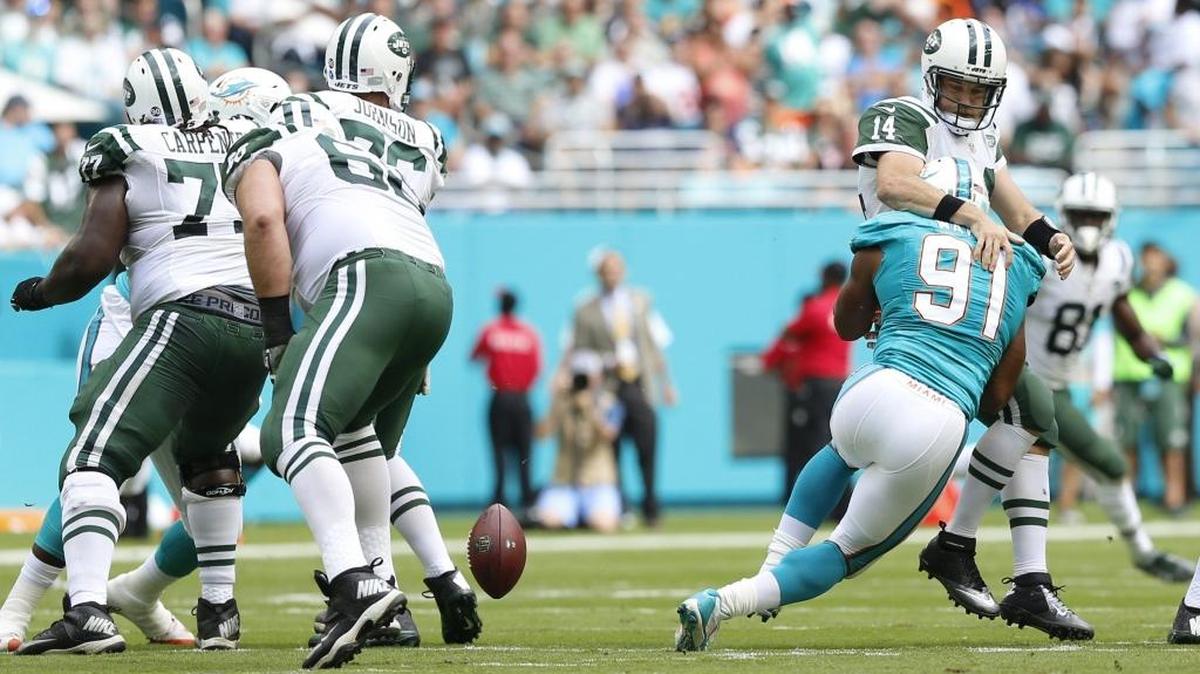 Cameron Wake (91), de los Dolphins, se lanza sobre el quarterback Ryan Fitzpatrick (14), el domingo en el Hard Rock Stadium.
