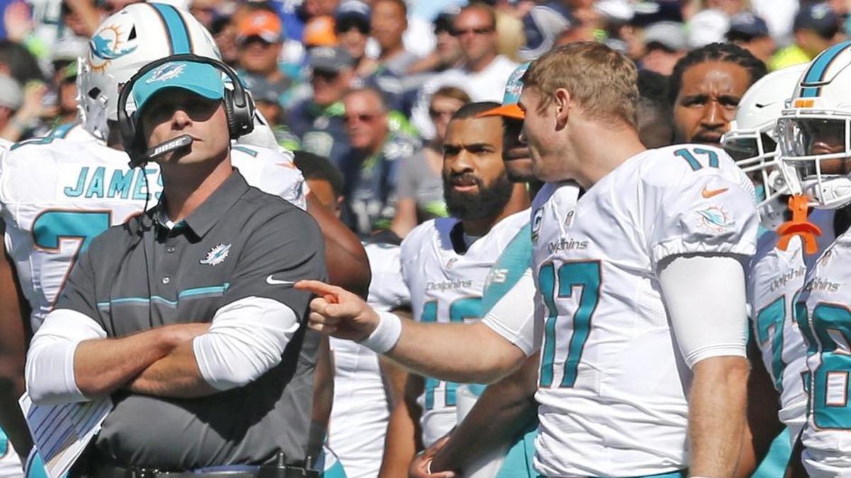 El quarterback de los Dolphins Ryan Tannehill (der.) conversa con el entrenador Adam Gase en el primer cuarto del partido contra los Seahawks, en el CenturyLink Field en Seattle, Washington, el domingo 11 de septiembre del 2016.