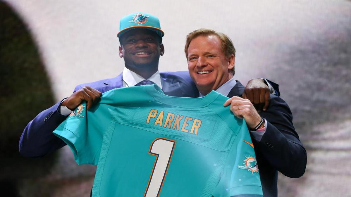 
DeVante Parker (izq.) y el comisionado Roger Goodell con la camiseta de los Dolphins, el jueves.
