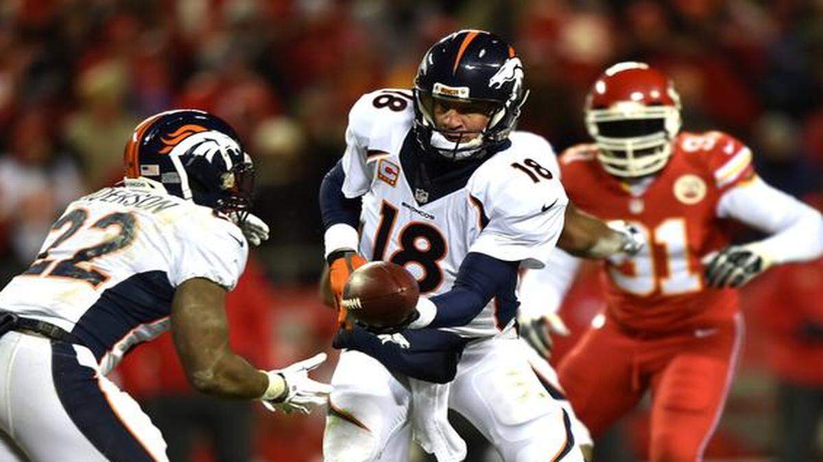 
El quarterback de los Broncos Peyton Manning (#18) pasa el ovoide al running back C.J. Anderson (#22), en el partido contra los Chiefs, el domingo en Kansas City.
