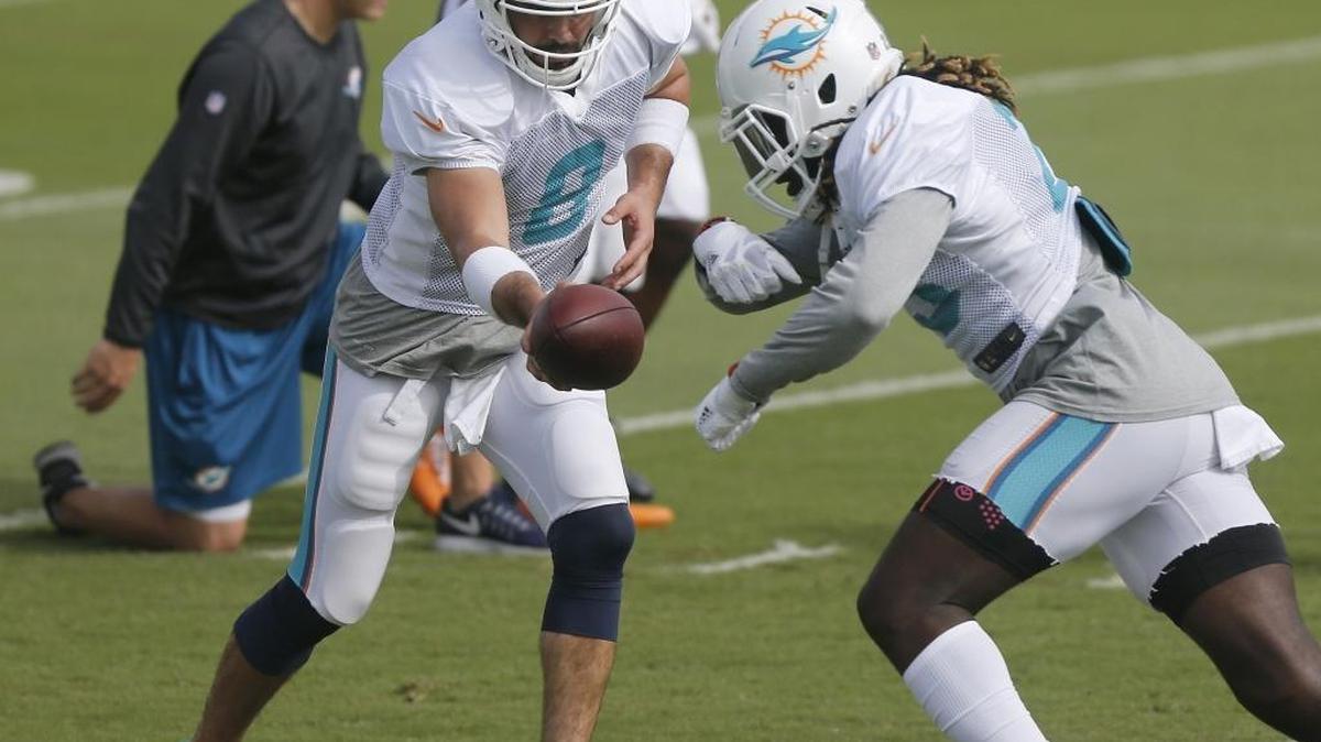 MATT MOORE ensaya la entrega del ovoide con Jay Ajayi (d) el 4 de enero en el centro de Davie.