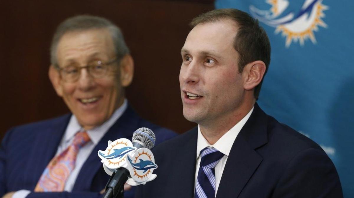 Stephen Ross (izq.), dueño de los Dolphins, escucha al nuevo entrenador Adam Gase, el sábado en Davie.
