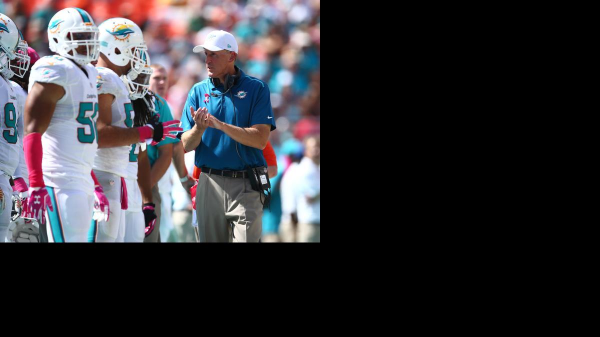 
El entrenador de los Dolphins Joe Philbin (der.) habla con sus jugadores en el juego ante los Packers.


