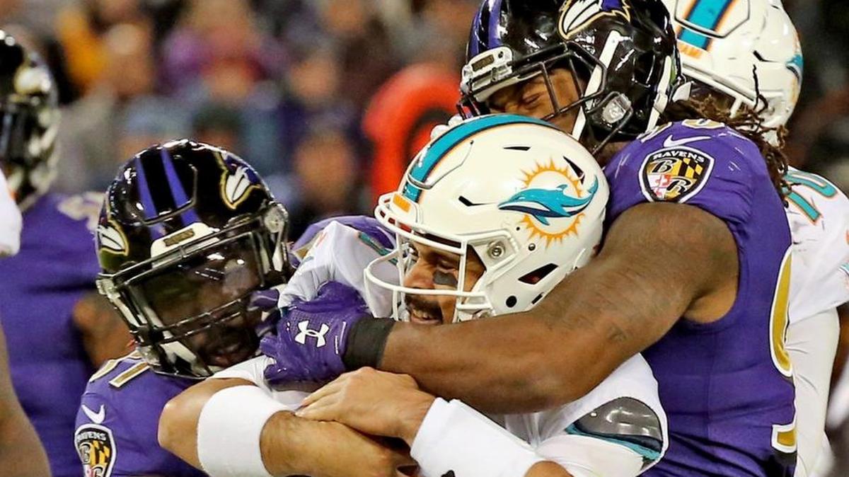 El quarterback Matt Moore (8), de los Dolphins, es derribado por Za'Darius Smith (90), de los Ravens, en el segundo cuarto en el M&T Bank Stadium en Baltimore, Maryland, la noche del jueves 26 de octubre del 2017.