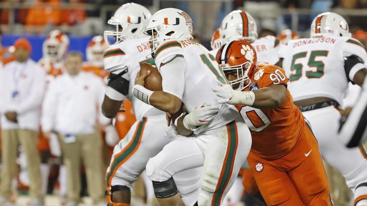El quarterback de los Huracanes Malik Rosier (12) es derribado por el defensive tackle de los Tigres Dexter Lawrence (90) en el juego de campeonato de la ACC celebrado este sábado 2 de diciembre en el Bank of America Stadium en Charlotte.